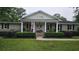 Charming single-story brick home with a welcoming front porch, manicured landscaping, and an American flag at 102 Ashborough Ave, Summerville, SC 29485