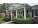 Inviting front porch with classic columns, hanging ferns, and manicured greenery, creating a welcoming entrance at 102 Ashborough Ave, Summerville, SC 29485