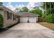 Spacious two-car garage with white doors and a wide driveway, complemented by brick exterior and landscaping at 102 Ashborough Ave, Summerville, SC 29485