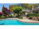 Serene backyard pool surrounded by lush greenery, brick accents, patio seating, and a partial view of the house at 102 Ashborough Ave, Summerville, SC 29485