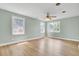 Bedroom featuring two bright windows, ceiling fan, light walls and wood-look flooring at 1027 E Recess Rd, Hanahan, SC 29410