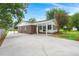 Brick home featuring a covered carport, mature shade trees, and a large driveway at 105 Bermuda Ct, Summerville, SC 29485
