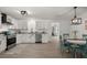 Modern kitchen featuring white cabinets, stainless steel appliances, and a dining area with colorful chairs at 105 Bermuda Ct, Summerville, SC 29485