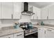 A close up of stainless steel stove and granite counter tops with white cabinets at 105 Bermuda Ct, Summerville, SC 29485