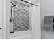 Well-lit bathroom showcasing a tiled shower with a shower curtain, alongside a towel rack at 1055 Royalist Rd, Mount Pleasant, SC 29464