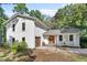 Charming painted brick home featuring a beautiful wood front door and attached garage surrounded by mature trees at 1055 Royalist Rd, Mount Pleasant, SC 29464