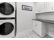Bright laundry room featuring a stacked washer and dryer and ample cabinet and countertop space at 1055 Royalist Rd, Mount Pleasant, SC 29464