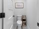 Clean powder room featuring a toilet, grey tiling, modern hardware, and neutral paint at 1055 Royalist Rd, Mount Pleasant, SC 29464
