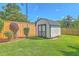 Backyard shed for extra storage near beautiful landscaping, green grass, and a wooden fence at 110 Salinas Ct, Summerville, SC 29483