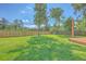 Large grassy backyard with a custom deck, wood fence, and mature trees, perfect for outdoor activities and relaxation at 110 Salinas Ct, Summerville, SC 29483