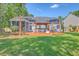 Expansive backyard featuring a custom deck with covered outdoor kitchen, bar and patio dining area, all surrounded by lush greenery at 110 Salinas Ct, Summerville, SC 29483