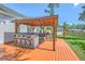 Outdoor kitchen with bar seating, grill, and wooden deck perfect for entertaining at 110 Salinas Ct, Summerville, SC 29483