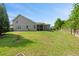 Spacious backyard with green grass, mature trees, and a view of the home's screened-in porch at 111 Gavins Way, Goose Creek, SC 29445