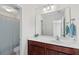 Bathroom features a cherry vanity with a white countertop and a shower with blue striped curtains at 111 Gavins Way, Goose Creek, SC 29445