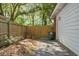 Small back patio shows trash can, bricks, leaves, and a closed wooden fence, all next to the white exterior of a house at 113 Owens Cir, Summerville, SC 29483