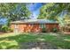 Brick house exterior from backyard showing windows and AC unit surrounded by mature trees and green grass at 113 Owens Cir, Summerville, SC 29483