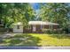 A charming brick and siding home nestled among mature trees, creating a welcoming and picturesque scene at 113 Owens Cir, Summerville, SC 29483