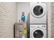 A well-organized laundry area features a stacked washer and dryer set and a water heater, efficiently utilizing space at 113 Owens Cir, Summerville, SC 29483