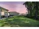 View of the cozy covered back patio and fenced backyard at dusk at 1132 Wading Point Blvd, Huger, SC 29450