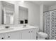 Bathroom featuring double vanity, mirrors, white cabinets, and shower with blue curtain at 1132 Wading Point Blvd, Huger, SC 29450