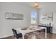 Dining area with white table and chairs adjacent to the open-concept kitchen and view outside the window at 1132 Wading Point Blvd, Huger, SC 29450