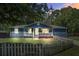 Charming blue home with a white picket fence and front porch at dusk at 116 Cone Ln, Summerville, SC 29483