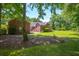 Exterior view of a brick home with mature trees and lush landscaping in a suburban setting at 121 Arrowridge Ct, Summerville, SC 29485