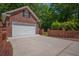 Exterior shot of a brick garage with a paved driveway and partial brick privacy wall at 121 Arrowridge Ct, Summerville, SC 29485