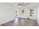 Bright living room with wood flooring, ceiling fan, and sun-drenched windows overlooking the front yard at 122 Mellard Dr, Goose Creek, SC 29445