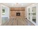 Open living room with brick fireplace, french doors to the porch, gray walls, and LVP flooring at 122 Mellard Dr, Goose Creek, SC 29445