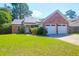 Charming brick home featuring a two-car garage, lush lawn, and solar panels for energy efficiency at 1287 Chatfield St, Mount Pleasant, SC 29464