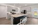 Bright kitchen featuring stainless appliances, granite counters and a black island with stools at 130 Spotted Way, Summerville, SC 29485