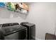 Modern laundry room with front loading washer and dryer, and ample shelving space at 130 Spotted Way, Summerville, SC 29485
