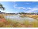Scenic pond view featuring a fountain, waterfront homes, and natural landscaping at 130 Spotted Way, Summerville, SC 29485