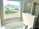 Bathroom tub with jets and window view, next to the glass enclosed shower at 1333 Song Sparrow Way, Hanahan, SC 29410