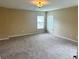 A neutral bedroom features neutral carpeting and natural light from the three windows at 1333 Song Sparrow Way, Hanahan, SC 29410