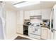 Compact kitchen maximizes space with white appliances and cabinets plus essential cooking equipment at 14 Lockwood Dr # 4C, Charleston, SC 29401