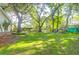 Expansive backyard with mature trees, lush green lawn, and a play set, offering ample space for outdoor activities at 1521 Wren Ave, Mount Pleasant, SC 29464