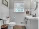 Bathroom with toilet, sink, mirror, wainscoting, neutral wall color and dark accents at 1521 Wren Ave, Mount Pleasant, SC 29464