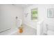 Well lit shower with decorative stool and tiled accent wall, window and toilet at 1655 Pinckney Park Dr, Charleston, SC 29407