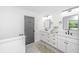 Bathroom featuring a double sink vanity, framed mirrors, and gray accent door at 1655 Pinckney Park Dr, Charleston, SC 29407