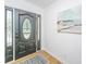 Elegant entryway with a black front door with glass inlays and a decorative rug on wood flooring at 1655 Pinckney Park Dr, Charleston, SC 29407