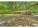 Charming single-story brick home with a lush lawn and mature trees, providing shade and curb appeal at 1655 Pinckney Park Dr, Charleston, SC 29407