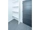 Hallway with gray tile floors, grey door, and built-in white shelving at 1655 Pinckney Park Dr, Charleston, SC 29407