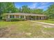 Charming single-story brick home with a lush lawn and mature trees, providing shade and curb appeal at 1655 Pinckney Park Dr, Charleston, SC 29407