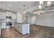 Open kitchen with island, white cabinets, stainless steel appliances, and hardwood flooring at 1671 Grange Cir, Summerville, SC 29486