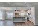 Open kitchen with island, white cabinets, stainless steel appliances, and hardwood flooring at 1671 Grange Cir, Summerville, SC 29486