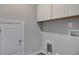 Bright laundry room with white cabinets and shelving and hardwood floors at 1671 Grange Cir, Summerville, SC 29486