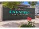 Welcoming sign for Paradiso, surrounded by greenery and flowers, creating a vibrant entrance at 1671 Indy Dr, North Charleston, SC 29405