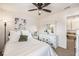 Bright bedroom featuring white walls, ceiling fan, and natural light with a bed, end tables and a dresser with a mirror at 1723 Indaba Way, Charleston, SC 29414